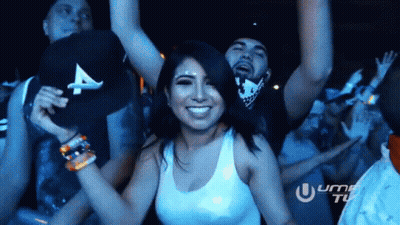 A Woman In A White Tank Top Is Dancing With A Man In A Black Hat With A On It GIF