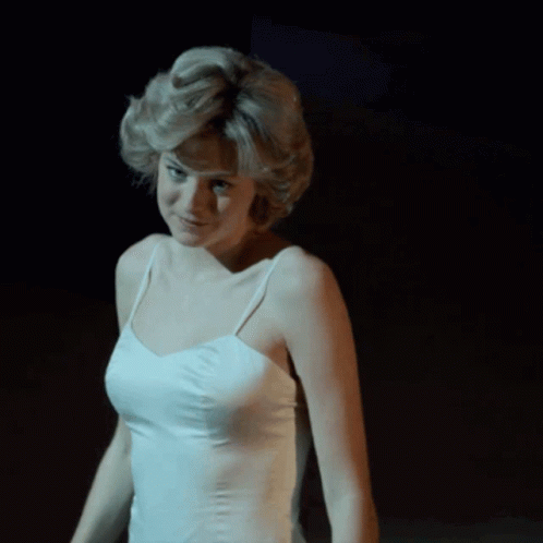 A Woman In A White Tank Top Is Smiling GIF