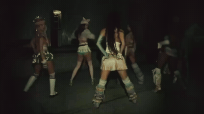A Woman In A White Top And Blue Gloves Is Dancing In Front Of Two Other Women . GIF