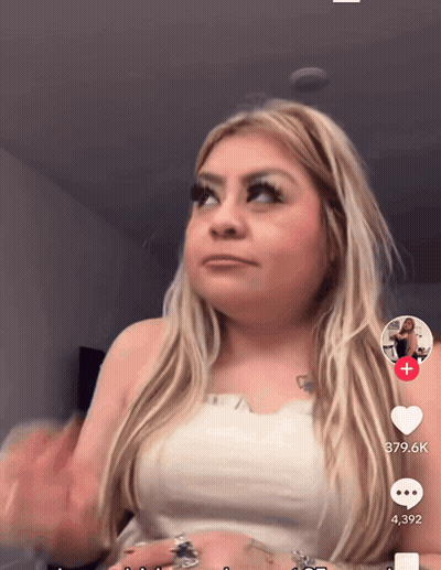 A Woman In A White Top Has A Tattoo Of A Heart On Her Arm GIF
