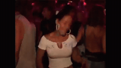 A Woman In A White Top Is Dancing In A Crowd GIF