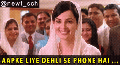 A Woman In A White Veil Is Smiling In Front Of A Group Of People GIF