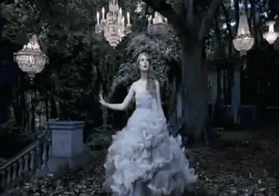 A Woman In A White Wedding Dress Is Dancing In A Dark Forest . GIF