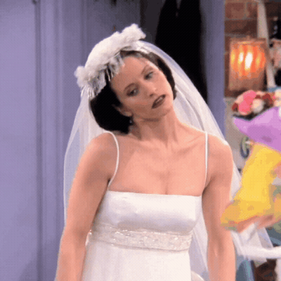 A Woman In A White Wedding Dress With A Veil GIF