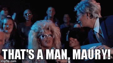 A Woman In A Wig And Glasses Says That 'S A Man Maury In Front Of A Group Of People GIF