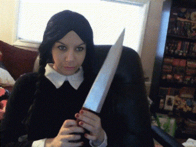 A Woman In A Wig Holds A Large Knife In Her Hands GIF