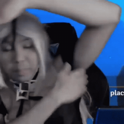 A Woman In A Wig Is Sitting In A Chair With A Sign That Says Place In The Background GIF