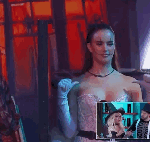 A Woman In A Witch Costume Is Standing Next To A Man In A Skeleton Outfit GIF