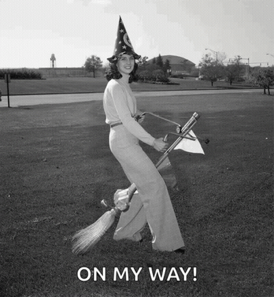 A Woman In A Witch Hat Is Flying On A Broom With The Words On My Way Written Below Her GIF