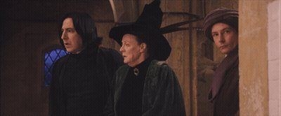 A Woman In A Witch Hat Is Standing Next To A Man GIF
