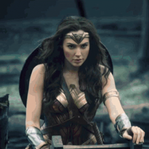 A Woman In A Wonder Woman Costume Holding A Sword GIF