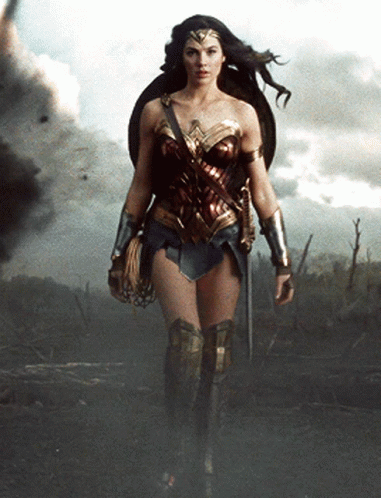 A Woman In A Wonder Woman Costume Holding A Sword And Shield GIF