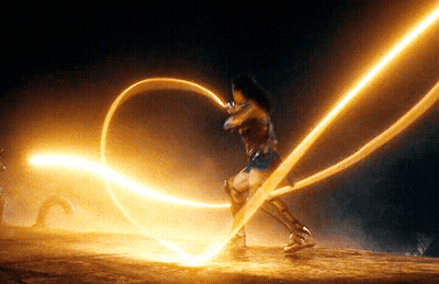 A Woman In A Wonder Woman Costume Is Holding A Glowing Rope . GIF