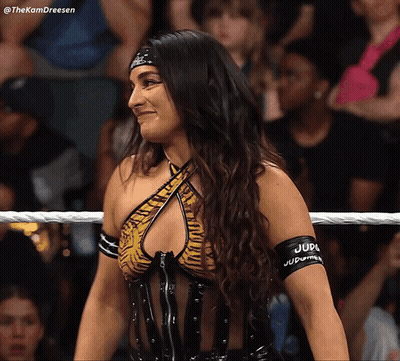 A Woman In A Wrestling Ring Has A Band Around Her Arm That Says Judge Judy GIF