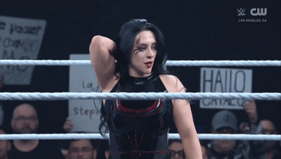 A Woman In A Wrestling Ring Has A Sign That Says Hallo On It GIF