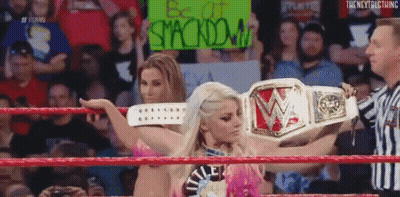 A Woman In A Wrestling Ring Holding A Sign That Says Be At Stackdown . GIF