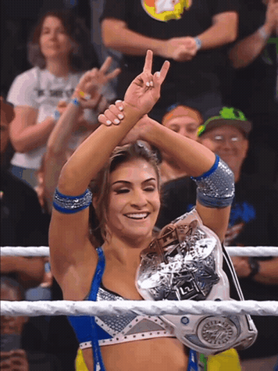 A Woman In A Wrestling Ring Holds A L2 Championship Belt GIF