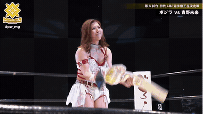 A Woman In A Wrestling Ring Is Holding A Trophy And The Hashtag #Fpw_mg Is Above Her GIF