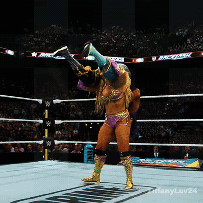 A Woman In A Wrestling Ring With A Sign That Says Prince In The Background GIF