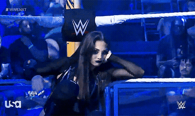 A Woman In A Wrestling Ring With A W Logo In The Background GIF