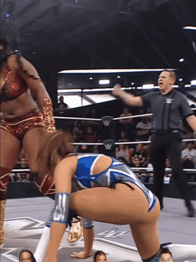 A Woman In A Wrestling Ring With A W Logo On The Wall GIF