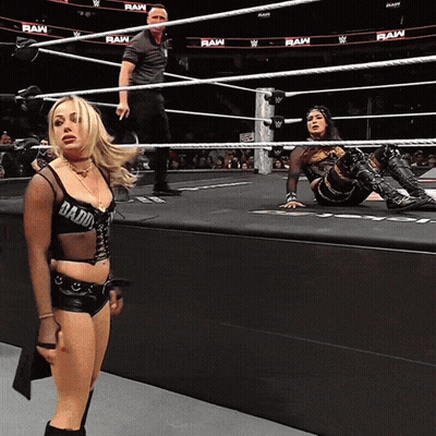 A Woman In A Wrestling Ring With Raw Written On The Walls GIF