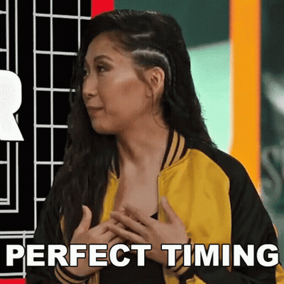A Woman In A Yellow And Black Jacket With The Words Perfect Timing Below Her GIF