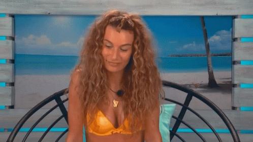 A Woman In A Yellow Bikini Sits On A Chair GIF