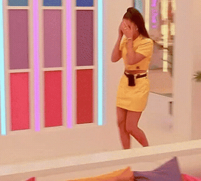 A Woman In A Yellow Dress Covering Her Face GIF