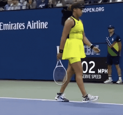 A Woman In A Yellow Dress Is Holding A Tennis Racquet On A Tennis Court .. GIF