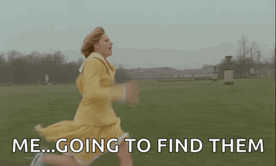 A Woman In A Yellow Dress Is Running Through A Grassy Field . GIF