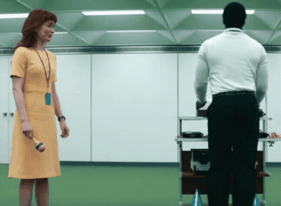 A Woman In A Yellow Dress Is Standing Next To A Man GIF