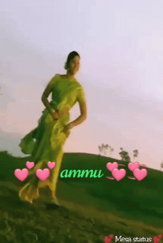 A Woman In A Yellow Dress Is Standing On A Hill With Hearts Around Her And The Words Ammu Written On The Bottom GIF