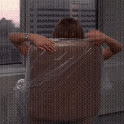 A Woman In A Yellow Dress Sits In A Chair With Her Legs Crossed GIF