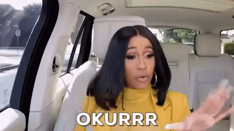 A Woman In A Yellow Jacket Is Sitting In The Back Seat Of A Car And Says Okurrr . GIF