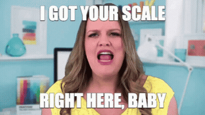 A Woman In A Yellow Shirt Is Screaming With The Words I Got Your Scale Right Here Baby Above Her GIF