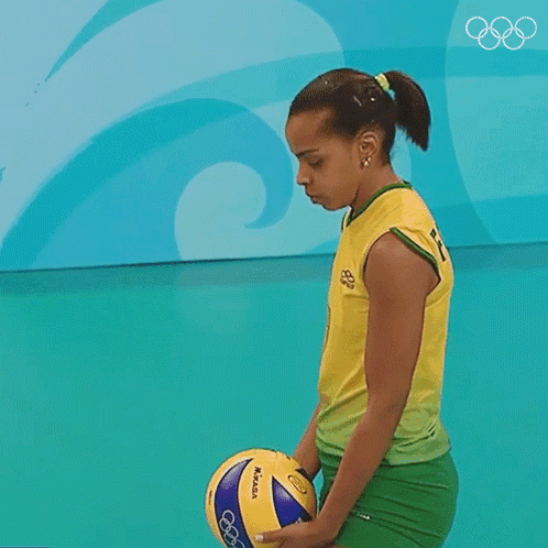 A Woman In A Yellow Shirt Is Serving A Volleyball In Front Of A Sign That Says B GIF