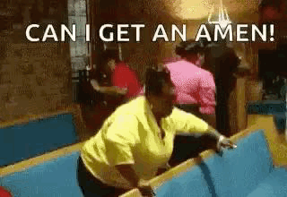A Woman In A Yellow Shirt Is Standing On A Bench In A Church And Says `` Can I Get An Amen '' . GIF