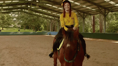 A Woman In A Yellow Sweater Riding A Brown Horse GIF