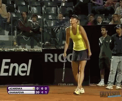 A Woman In A Yellow Tank Top Stands On A Tennis Court In Front Of An Enel Banner GIF