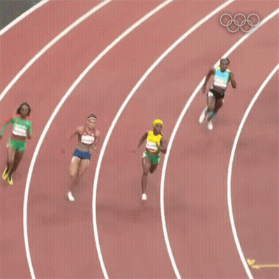 A Woman In A Yellow Top And Green Shorts With The Number 6 On Her Shorts Is Running On A Track . GIF