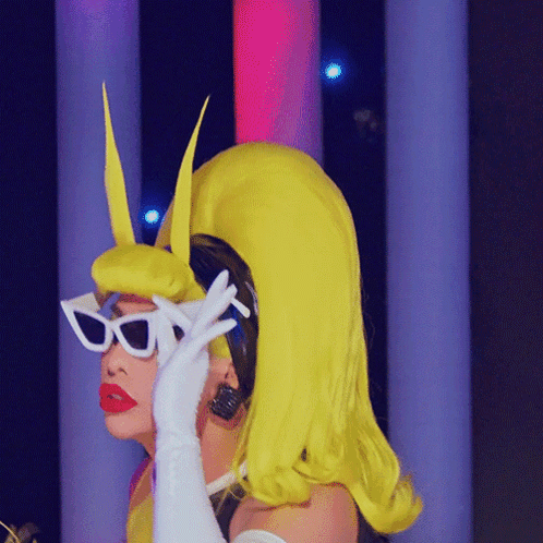 A Woman In A Yellow Wig And White Sunglasses GIF
