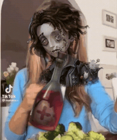 A Woman In A Zombie Costume Is Drinking From A Bottle While Eating Vegetables . GIF