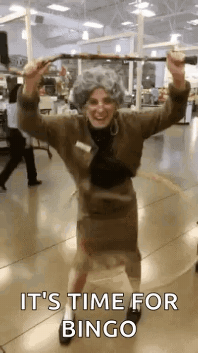 A Woman In An Elderly Woman Costume Is Holding A Cane And Dancing In A Store . GIF
