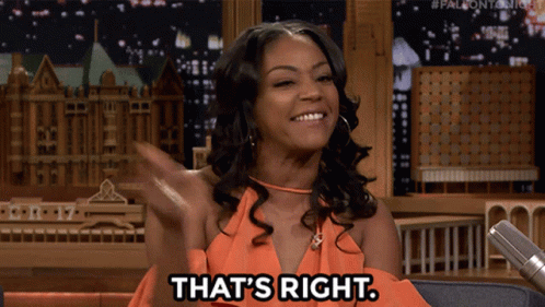 A Woman In An Orange Dress Says That 'S Right In Front Of A Microphone GIF