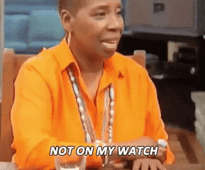 A Woman In An Orange Shirt Is Sitting At A Table With A Glass Of Water And Says `` Not On My Watch '' . GIF