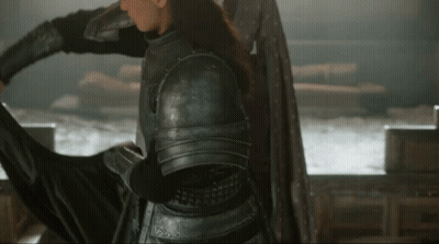 A Woman In Armor Is Holding A Sword In Her Hand GIF
