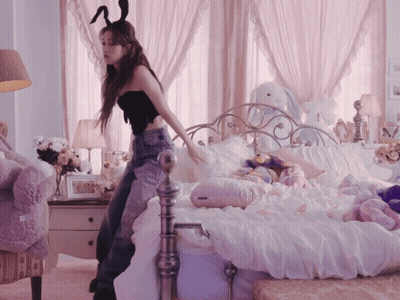 A Woman In Bunny Ears Stands On A Bed GIF