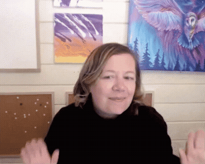 A Woman In Front Of A Painting Of An Owl With Wings GIF