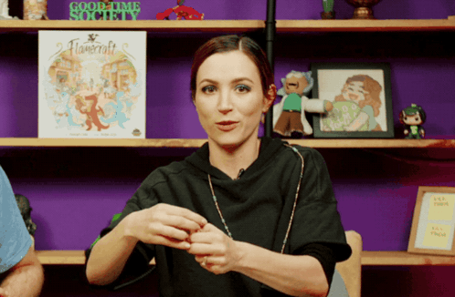 A Woman In Front Of A Shelf With A Sign That Says Goodtime Society GIF